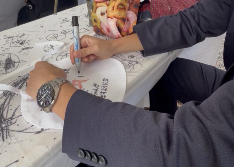 中山寺にて願布に願い事を記入している夫の姿