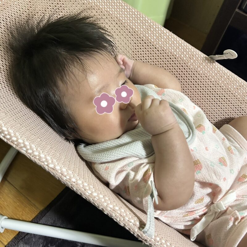 じーっと右手を見つめる生後3か月の赤ちゃん
