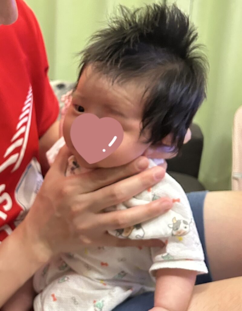 げっぷが出るのを待ってる生後二か月過ぎの赤ちゃん