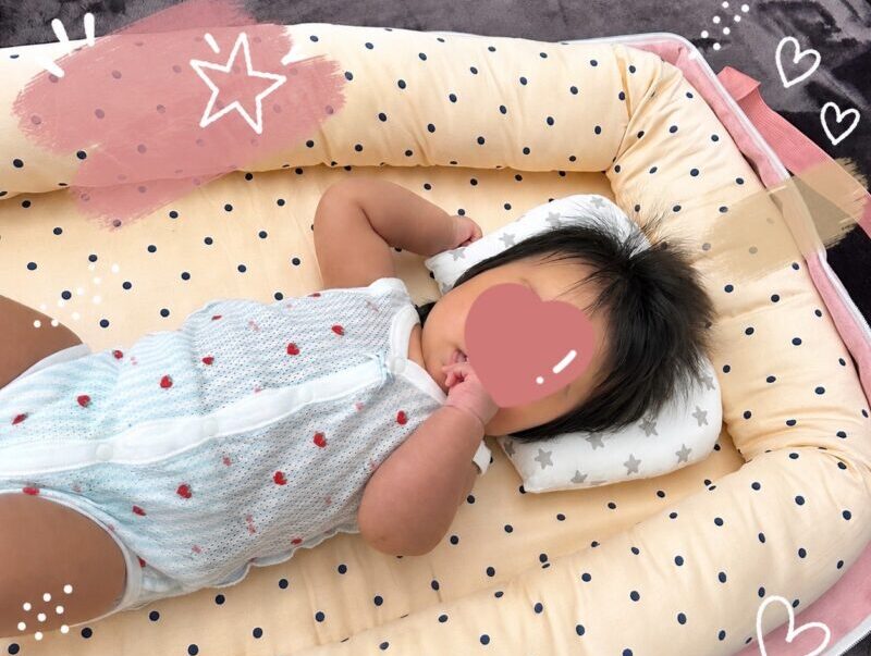 折りたたみベビーベッドに寝転ぶ赤ちゃん